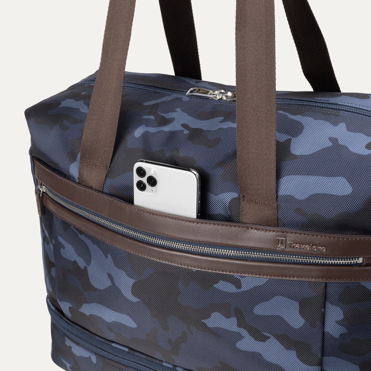 Close-up view of Travelpro Platinum Elite Drop-Bottom Weekender in Navy Camouflage with phone in QuickSlip front pocket.

