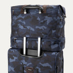 Rear view of Travelpro Platinum Elite Drop-Bottom Weekender in Navy Camouflage stacked on luggage handle using rear stacking strap.
