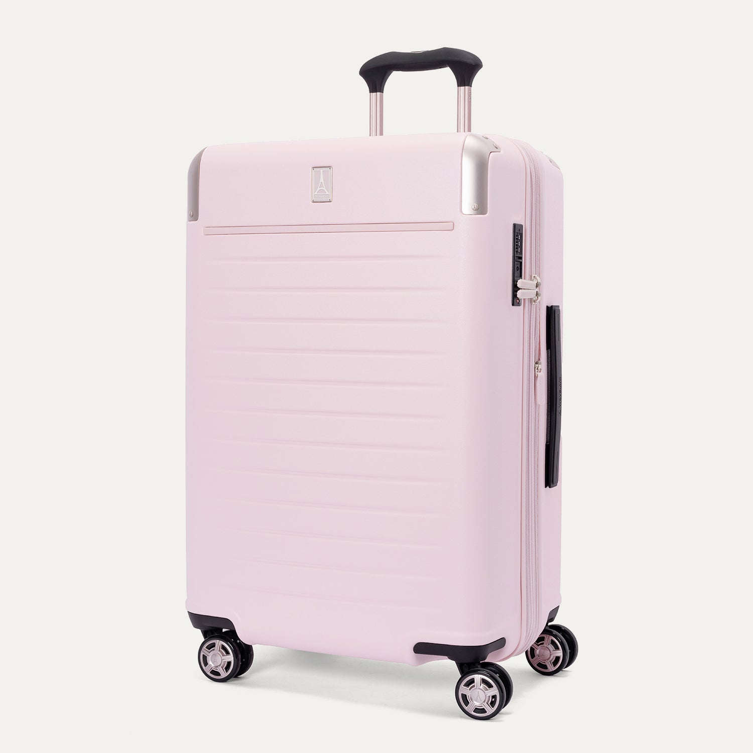 Three-quarter front view of the Travelpro Platinum Elite Medium Check-In Hardside Spinner in Powder Pink, featuring a durable polycarbonate shell with polished aluminum corner armor, an extended telescopic handle, and multi-directional wheels against a clean off-white background.