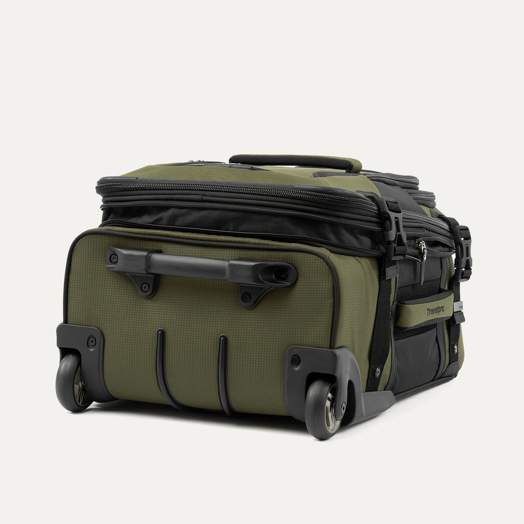 low-angle rear view of the olive black bold by travelpro carry-on expandable rollaboard suitcase resting horizontally, showcasing its two high-performance ball-bearing wheels, heavy-duty protective skid guards, and the molded housing around the retracted telescoping handle.