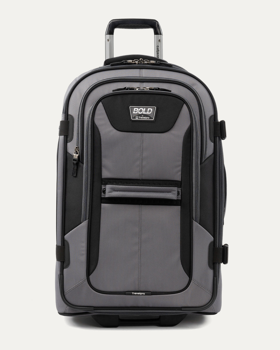 front view of the gray black bold by travelpro medium check-in expandable rollaboard suitcase standing upright, showcasing its rugged black and gray polyester exterior, spacious front zippered pocket, sturdy rubberized carry handle, and extended telescoping aircraft-grade handle.