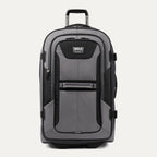 front view of the gray black bold by travelpro large check-in expandable rollaboard suitcase standing upright, showcasing its rugged black and gray polyester exterior, spacious front zippered pocket, sturdy rubberized carry handle, and extended telescoping aircraft-grade handle.