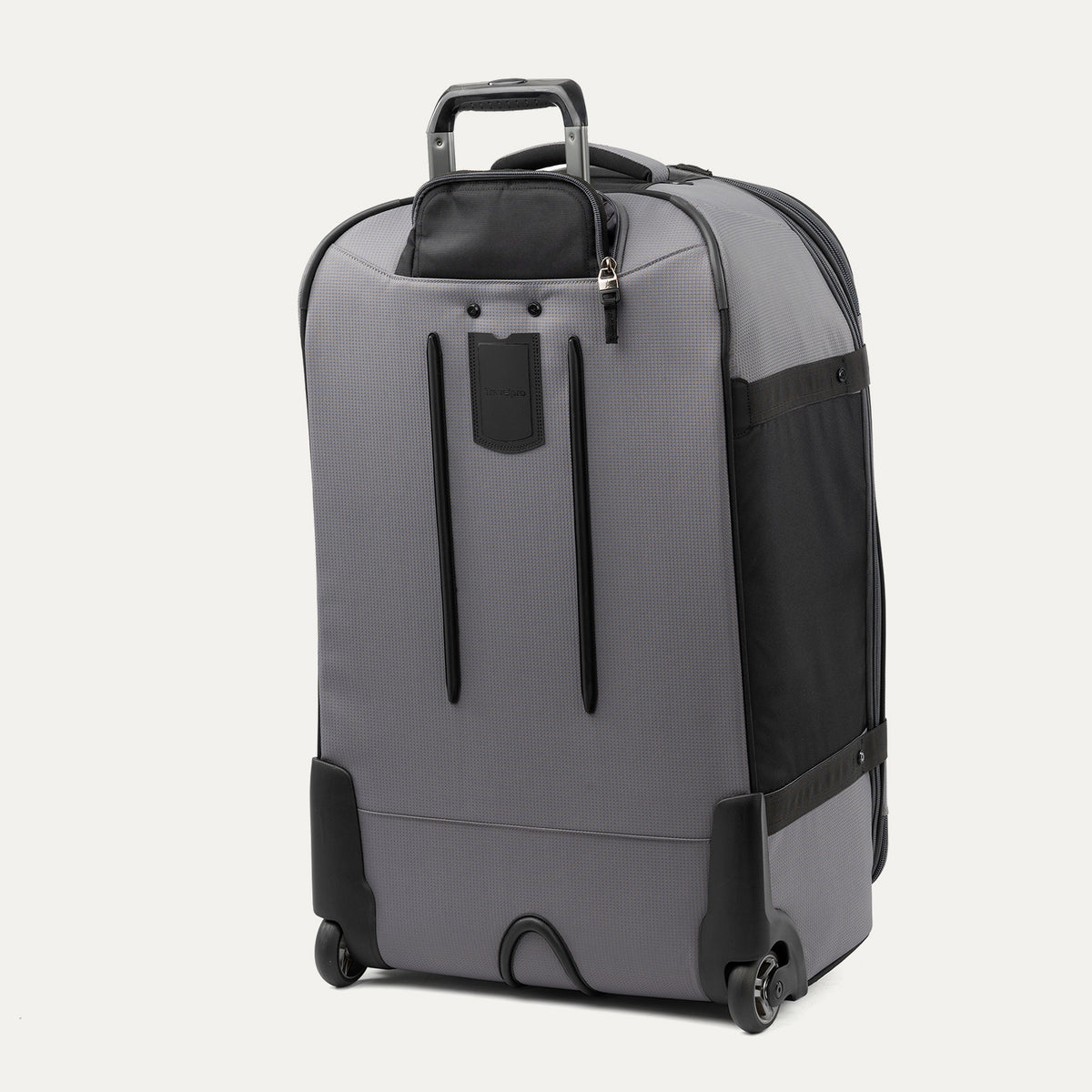 rear three-quarter view of the gray black bold by travelpro large check-in expandable rollaboard suitcase standing vertically, showing its protective skid guards, molded corner guards, reinforced wheel housings, two high-performance ball-bearing wheels, and extended telescoping handle.