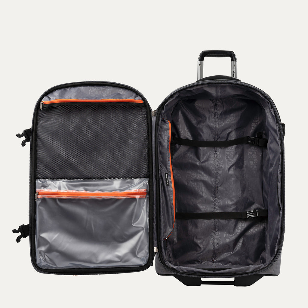 interior view of the open gray black bold by travelpro large check-in expandable rollaboard suitcase showing a spacious main compartment with two adjustable hold-down straps and a large zippered mesh lid pocket alongside a clear plastic wet pocket with orange zipper trim.