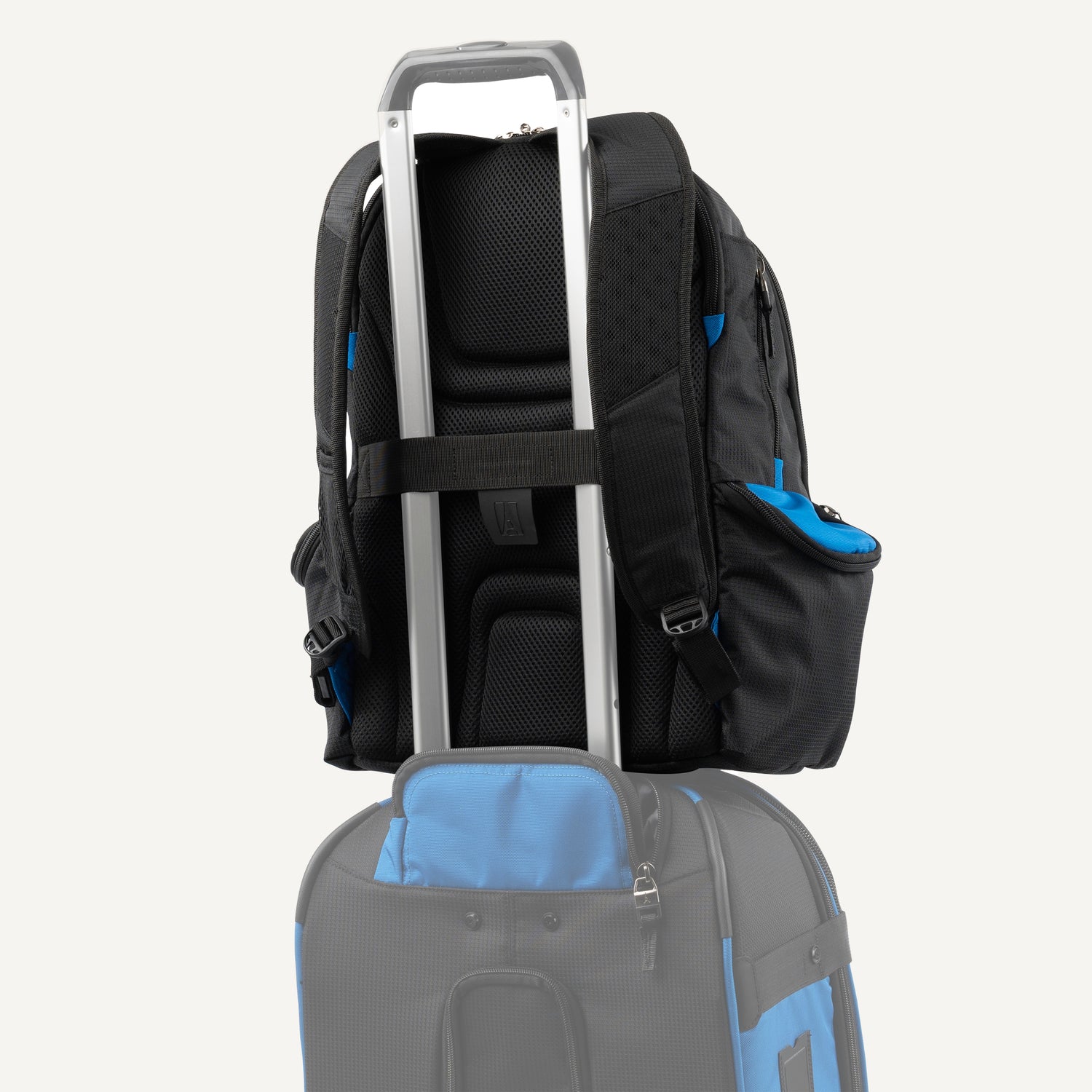 Black and blue backpack stacked on top of a suitcase 