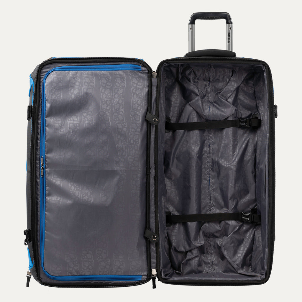 interior view of the open blue black bold by travelpro large check-in drop-bottom rolling duffel bag showing the spacious main compartment with two adjustable tie-down straps and a large zippered mesh pocket on the inside lid.