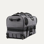 low-angle rear view of the gray black bold by travelpro large check-in drop-bottom rolling duffel bag resting horizontally, showcasing its two high-performance wheels, heavy-duty bottom skid guards, and the retracted telescoping handle base.