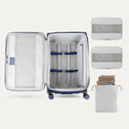 Open suitcase with packing accessories on a white background