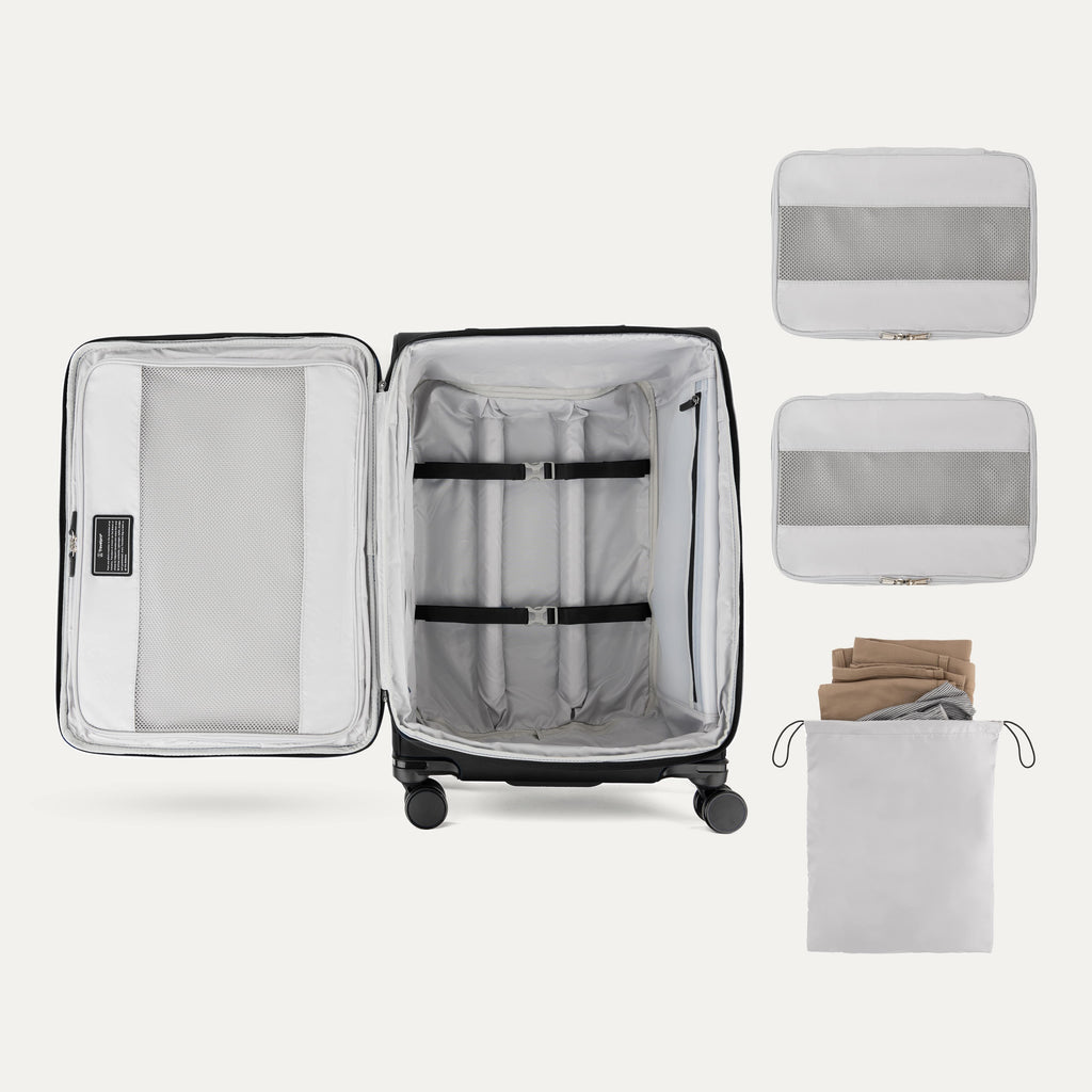 Interior of Travelpro Versapack Checked Luggage in Black, showing packing cubes, laundry bag, and adjustable hold-down straps.
