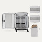 Interior of Travelpro Versapack Checked Luggage in Black, showing packing cubes, laundry bag, and adjustable hold-down straps.

