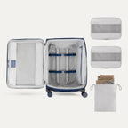 Interior of Travelpro Versapack Checked Luggage in Estate Blue, showing packing cubes, laundry bag, and adjustable hold-down straps.