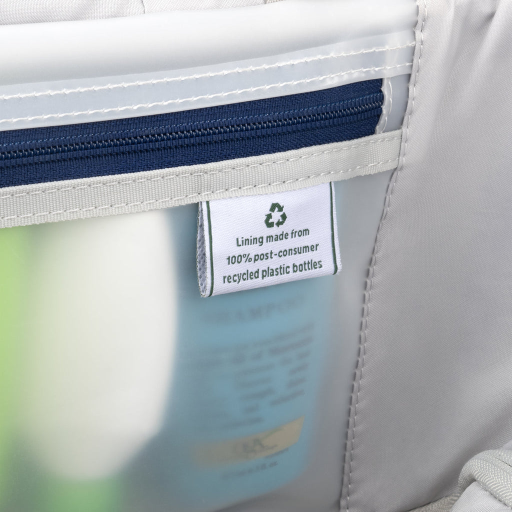 Interior lining tag on a Travelpro suitcase, highlighting construction from 100% post-consumer recycled plastic bottles.
