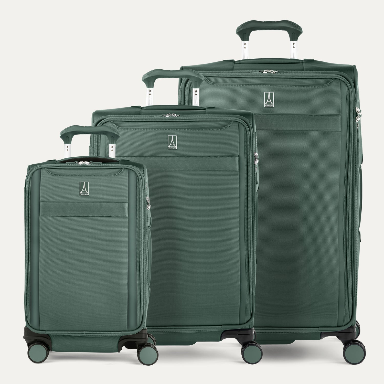 A set of three green VersaPack+ expandable spinner suitcases, including a carry-on size, a medium check-in size, and a large check-in size, displayed with their handles extended in  Desert Sage Green.