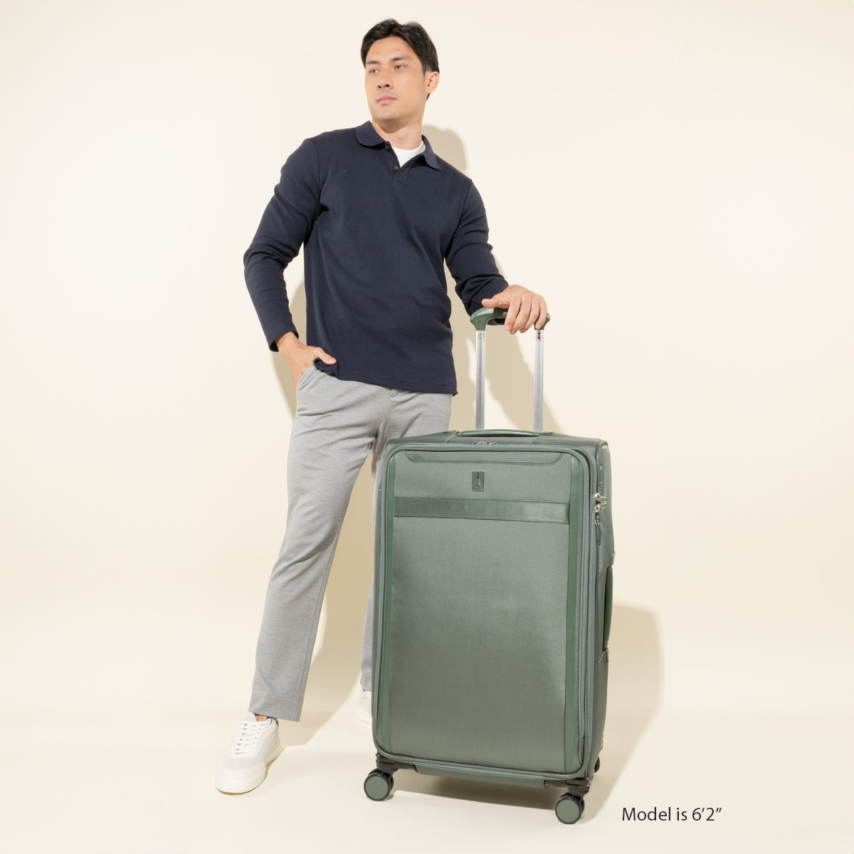 Man Standing with the Softsided VersaPack+ Extra Large Checked Luggage Spinner in Green