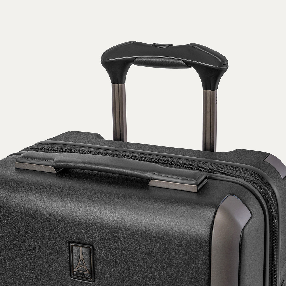 Close-up of the leather-wrapped top handle and PowerScope Lite extension handle on the Travelpro Platinum Reserve Compact Carry-On Hardside Spinner in Black Dust