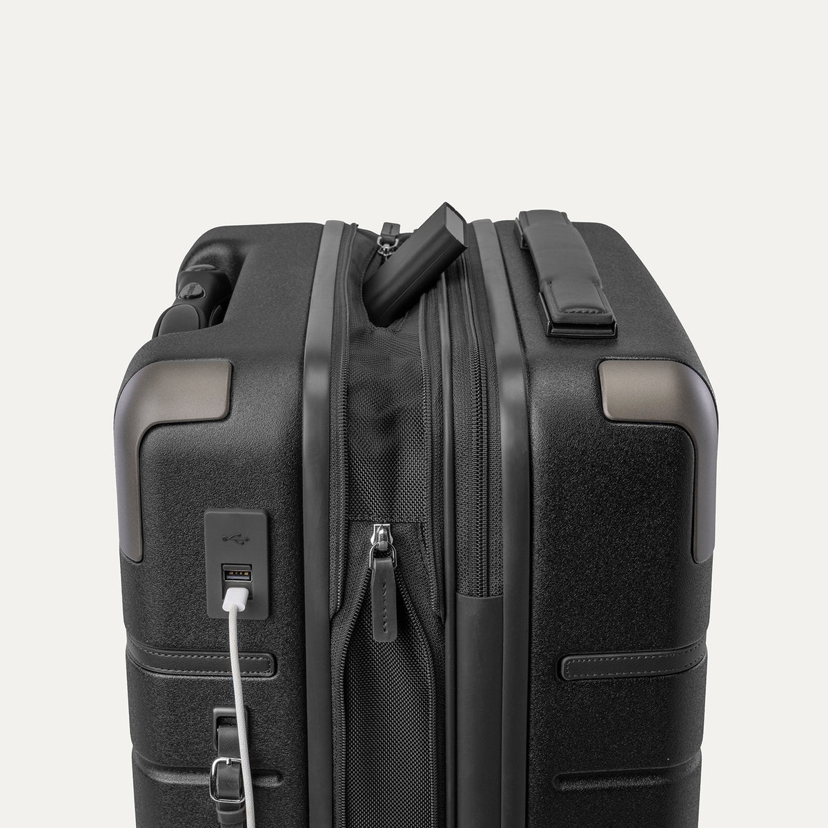 Charging cable plugged into the external USB port on the Travelpro Platinum Reserve Compact Carry-On Hardside Spinner in Black Dust