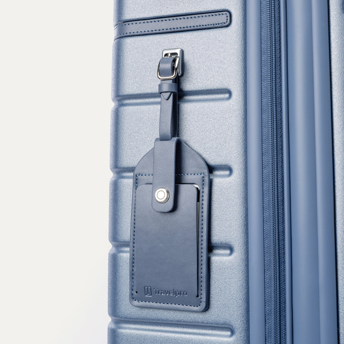 Close-up of the full-grain leather luggage tag on the Travelpro Platinum Reserve Compact Carry-On Hardside Spinner in Steel Blue