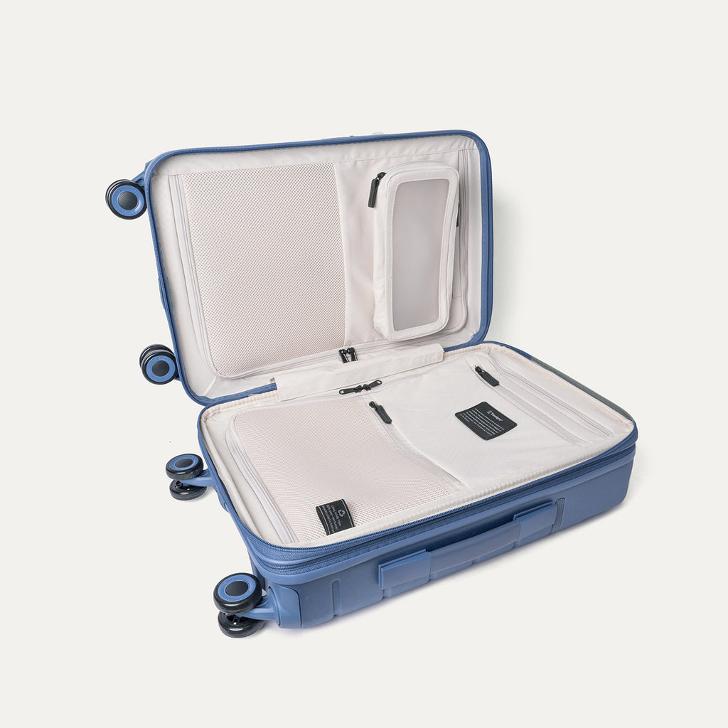 Open interior of the Travelpro Platinum Reserve Compact Carry-On Hardside Spinner in Steel Blue showing the zippered divider panel and dedicated pockets