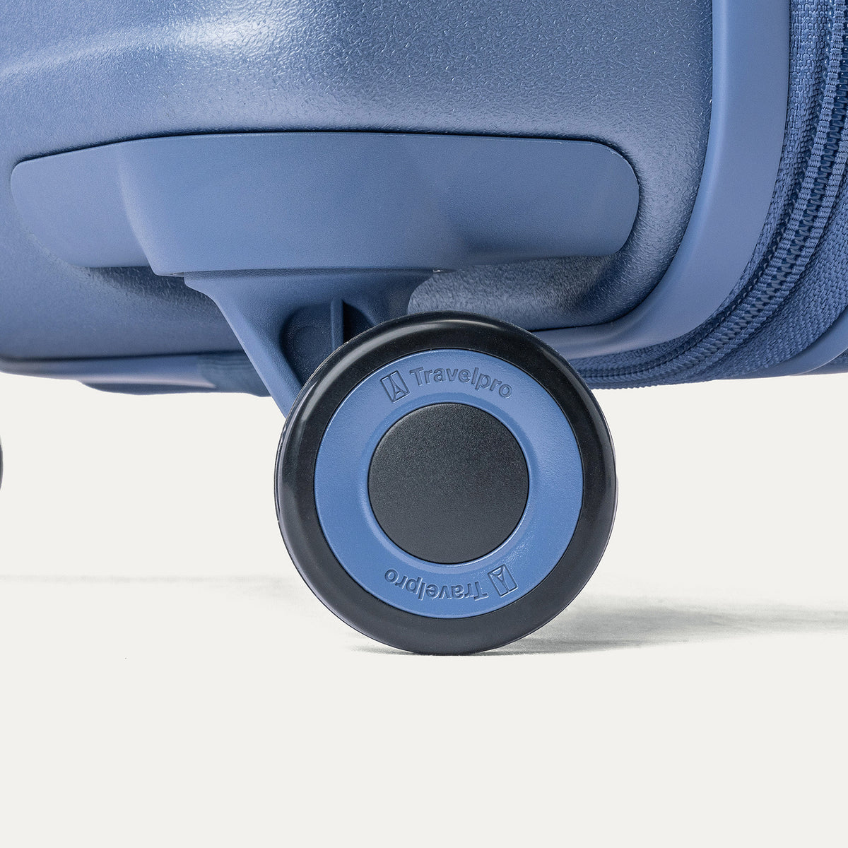 Close-up of a MagnaTrac self-aligning spinner wheel on the Travelpro Platinum Reserve Compact Carry-On Hardside Spinner in Steel Blue