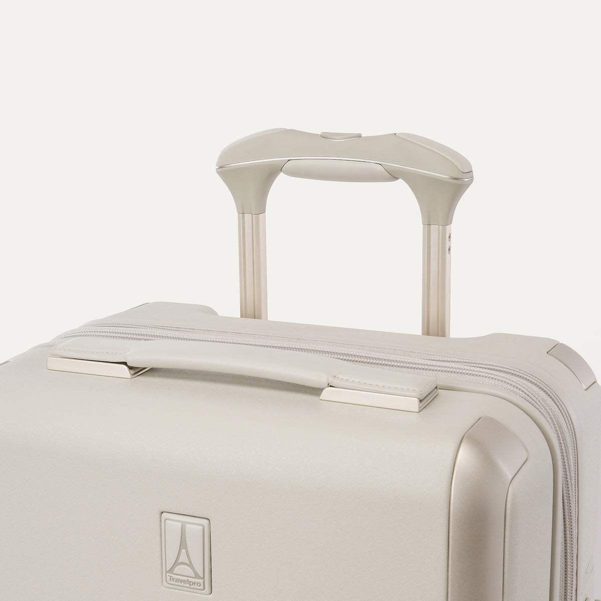 Close-up of the leather-wrapped top handle and PowerScope Lite extension handle on the Travelpro Platinum Reserve Compact Carry-On Hardside Spinner in Sandstone