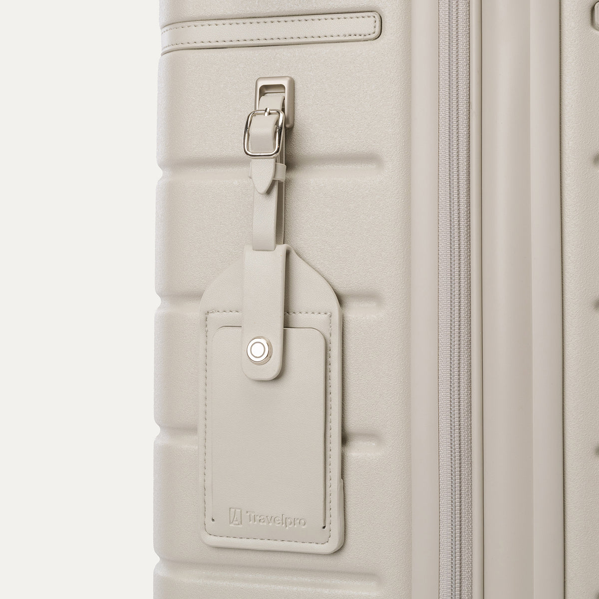 Close-up of the full-grain leather luggage tag on the Travelpro Platinum Reserve Compact Carry-On Hardside Spinner in Sandstone