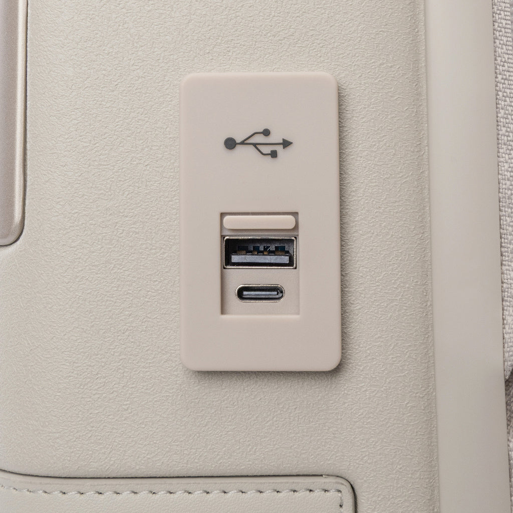 Close-up of the external USB-A and USB-C charging ports on the Travelpro Platinum Reserve Compact Carry-On Hardside Spinner in Sandstone