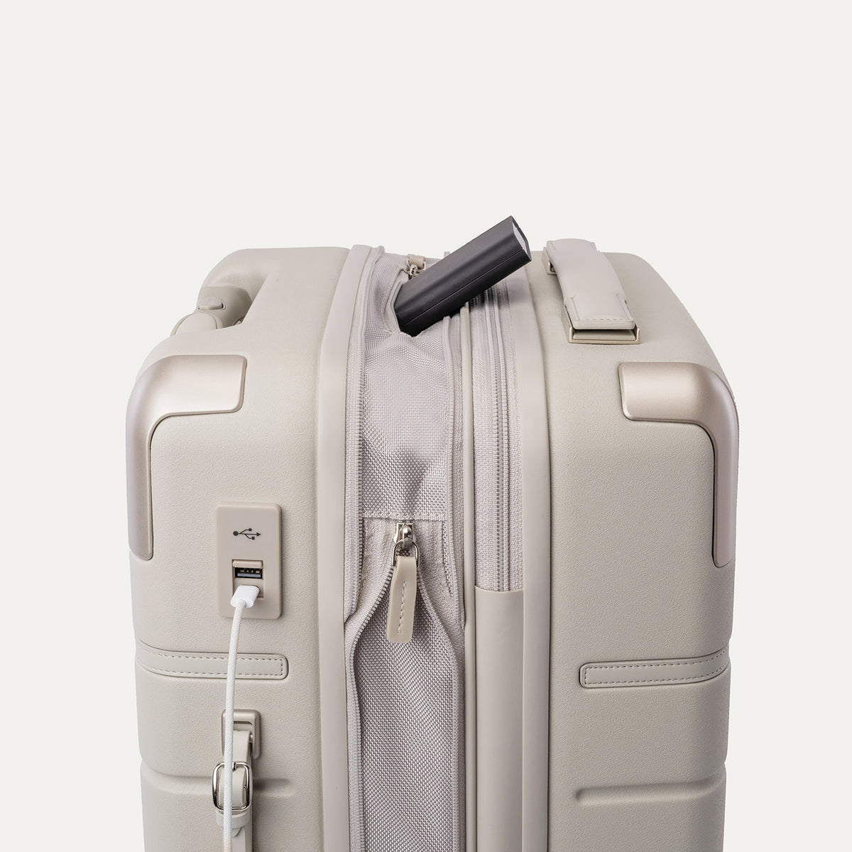 Charging cable plugged into the external USB port on the Travelpro Platinum Reserve Compact Carry-On Hardside Spinner in Sandstone
