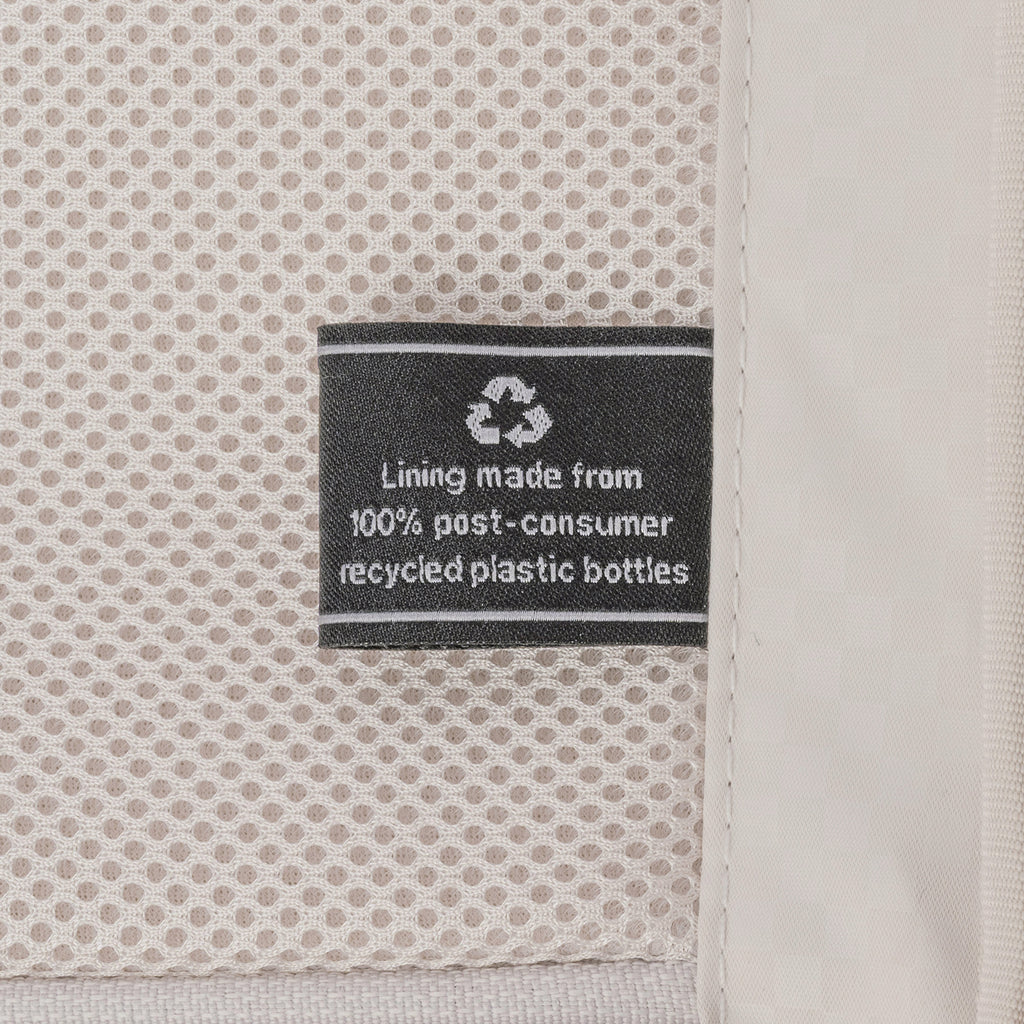 ECOFAB lining label inside the Travelpro Platinum Reserve Compact Carry-On Hardside Spinner in Sandstone, made from 100% post-consumer recycled plastic bottles