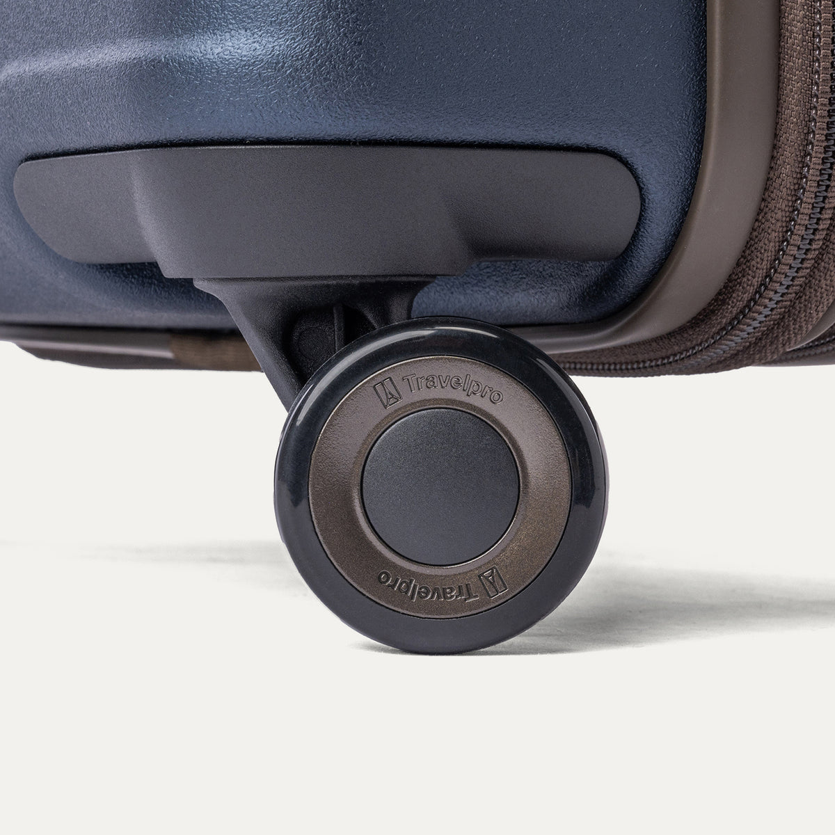 Close-up of a MagnaTrac self-aligning spinner wheel on the Travelpro Platinum Reserve Compact Carry-On Hardside Spinner in Midnight Trail