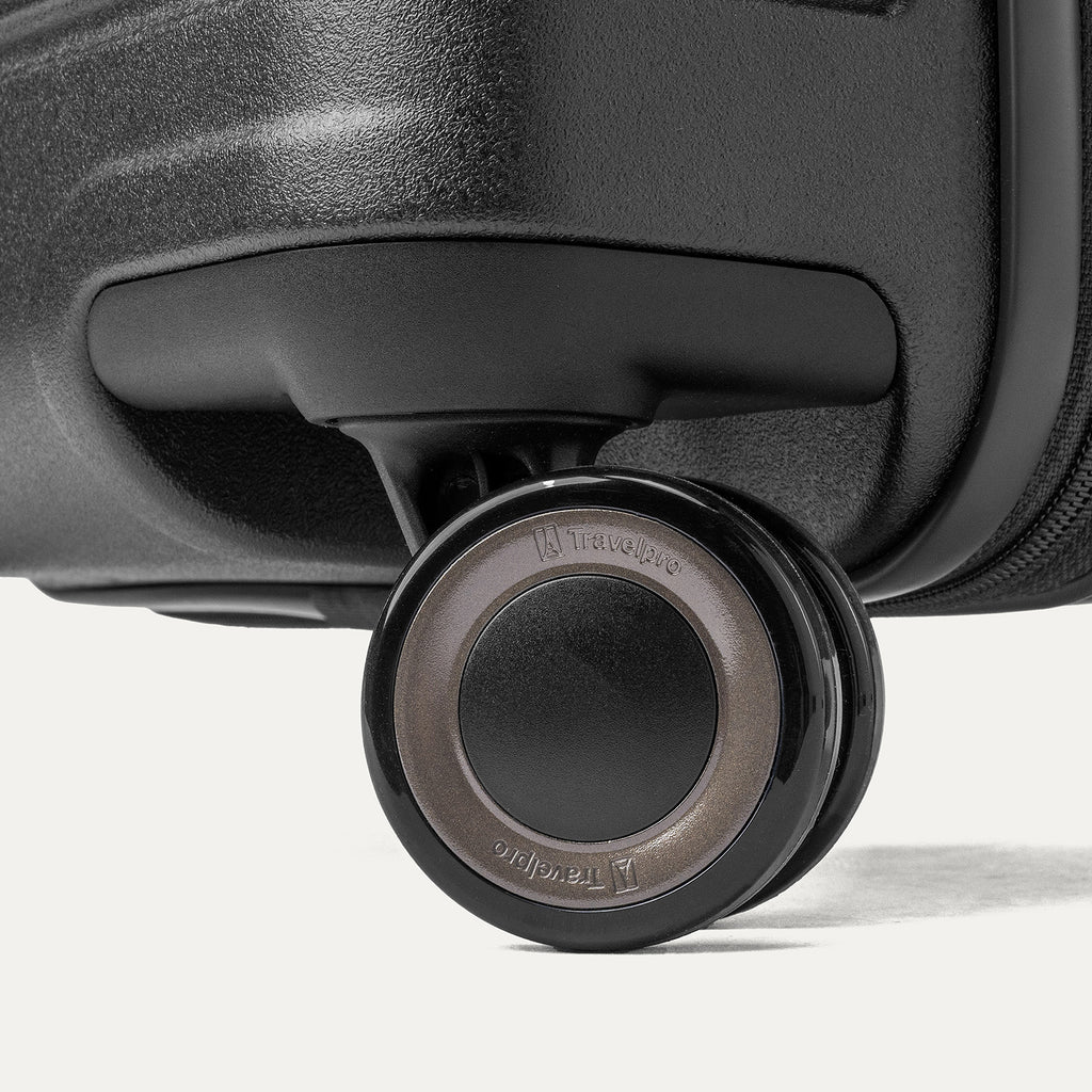Close-up of a MagnaTrac self-aligning spinner wheel on the Travelpro Platinum Reserve Carry-On Hardside Spinner in Black Dust
