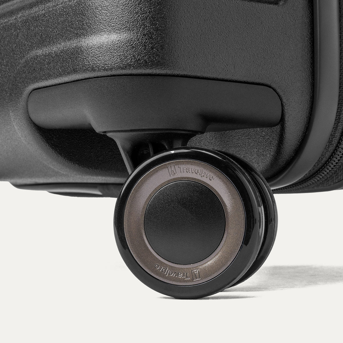 Close-up of a MagnaTrac self-aligning spinner wheel on the Travelpro Platinum Reserve Carry-On Hardside Spinner in Black Dust