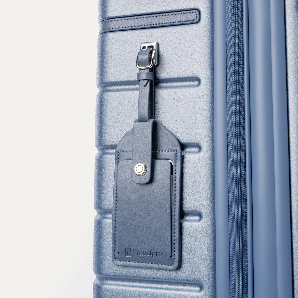 Close-up of the full-grain leather luggage tag on the Travelpro Platinum Reserve Carry-On Hardside Spinner in Steel Blue
