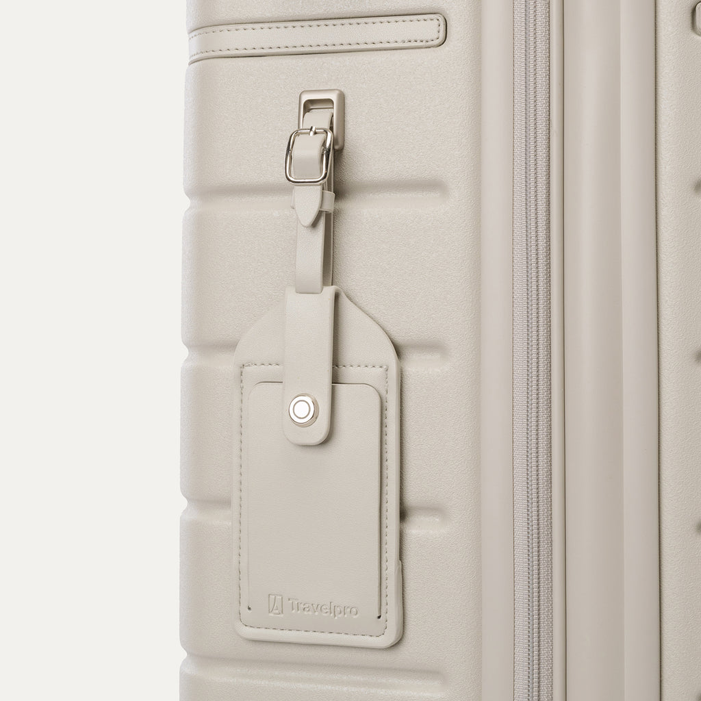Close-up of the full-grain leather luggage tag on the Travelpro Platinum Reserve Carry-On Hardside Spinner in Sandstone