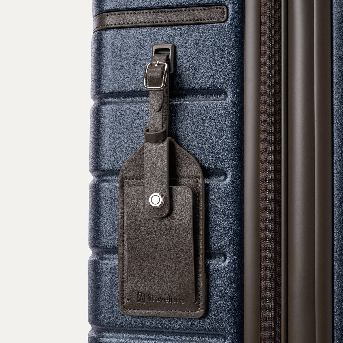 Close-up of the full-grain leather luggage tag on the Travelpro Platinum Reserve Carry-On Hardside Spinner in Midnight Trail