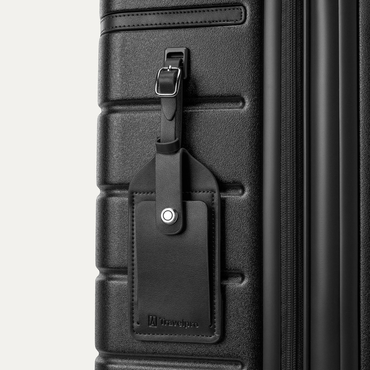 Close-up of the full-grain leather luggage tag on the Travelpro Platinum Reserve Medium Check-In Hardside Spinner in Black Dust