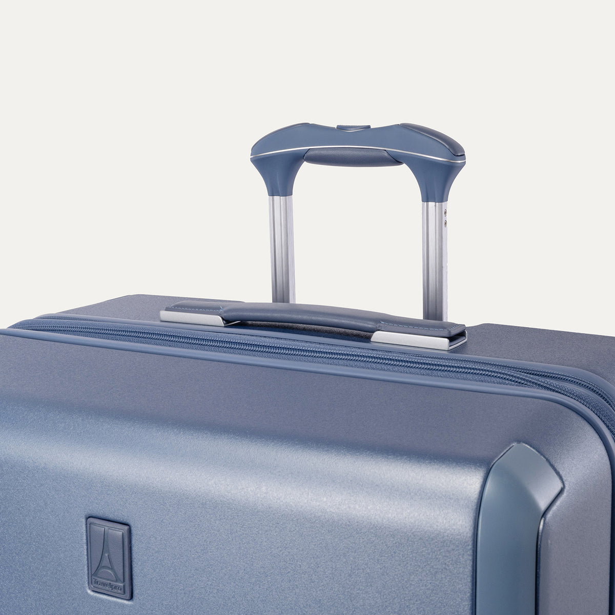 Close-up of the leather-wrapped top handle and PowerScope Lite extension handle on the Travelpro Platinum Reserve Medium Check-In Hardside Spinner in Steel Blue