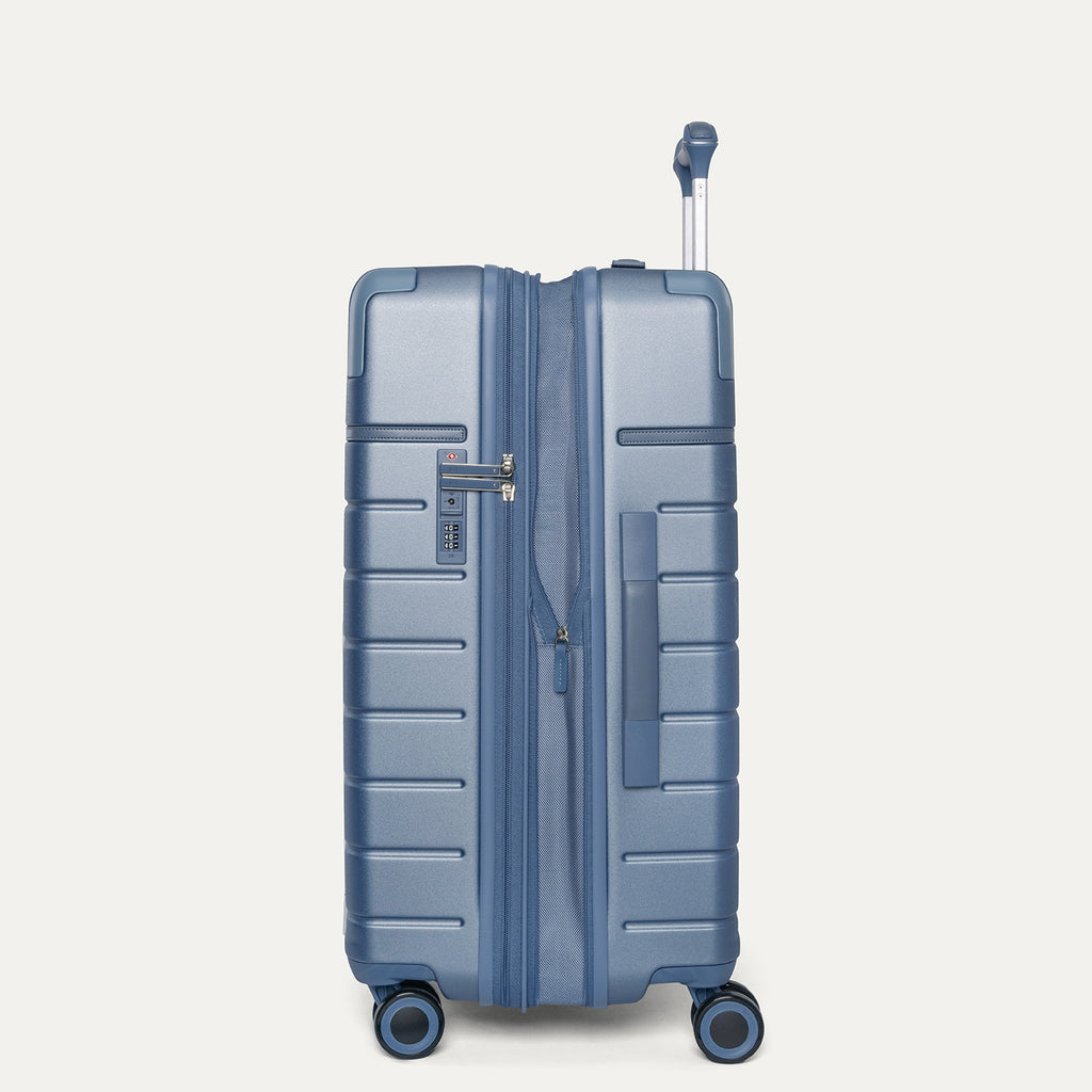 Side profile of the Travelpro Platinum Reserve Medium Check-In Hardside Spinner in Steel Blue, expanded for extra packing space