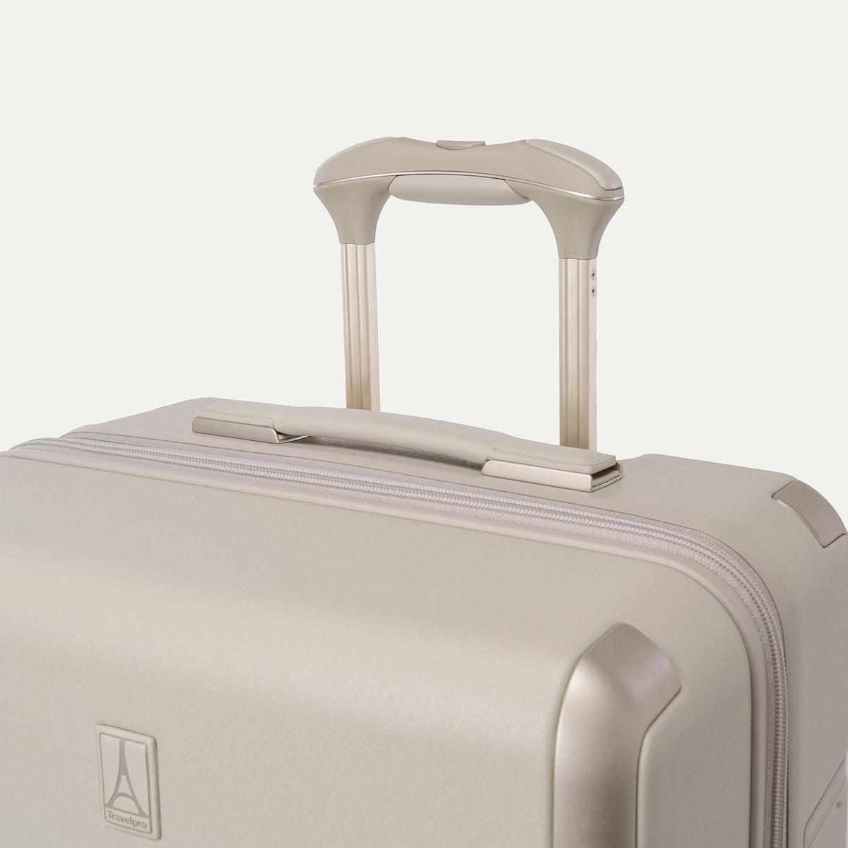 Close-up of the leather-wrapped top handle and PowerScope Lite extension handle on the Travelpro Platinum Reserve Medium Check-In Hardside Spinner in Sandstone