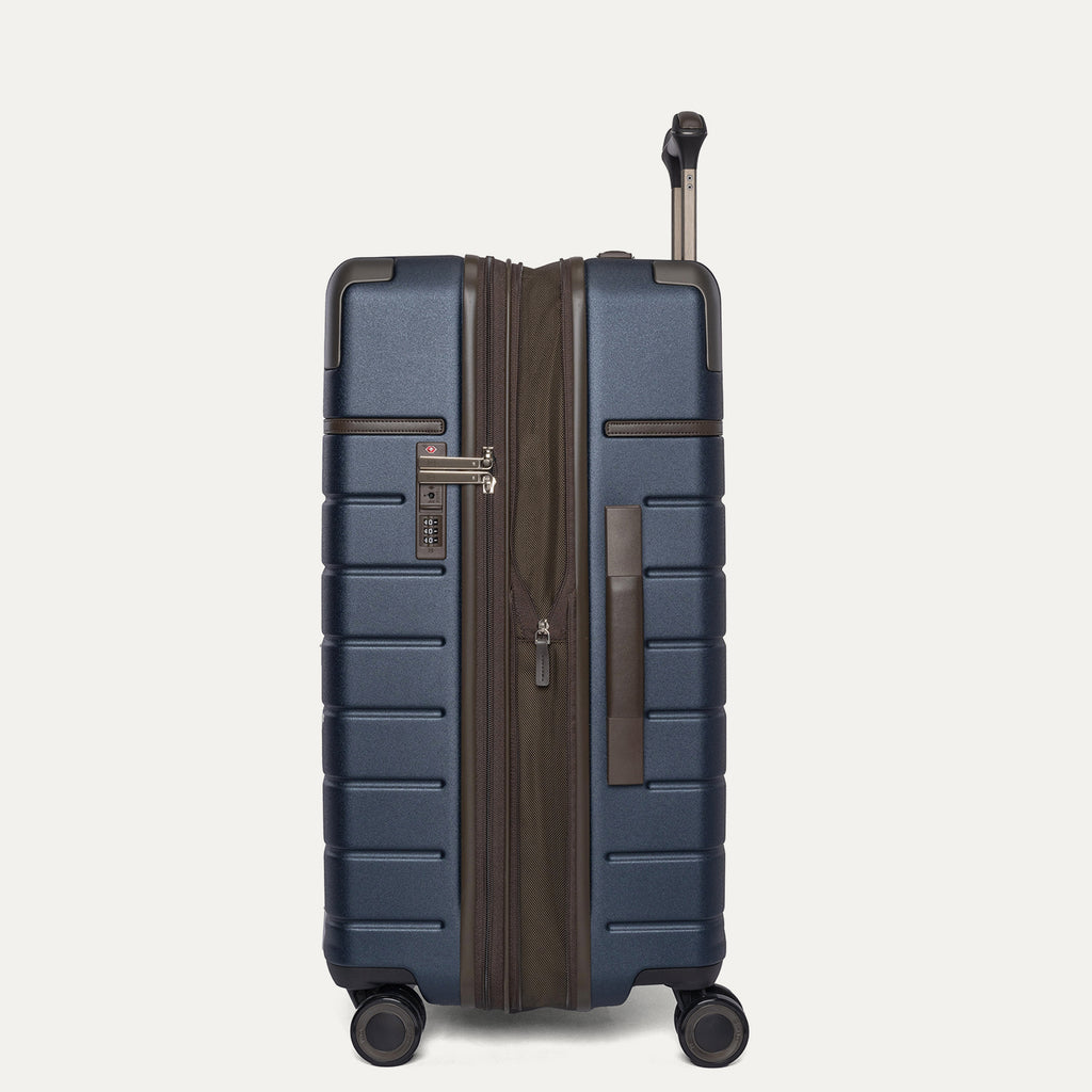 Side profile of the Travelpro Platinum Reserve Medium Check-In Hardside Spinner in Midnight Trail, expanded for extra packing space