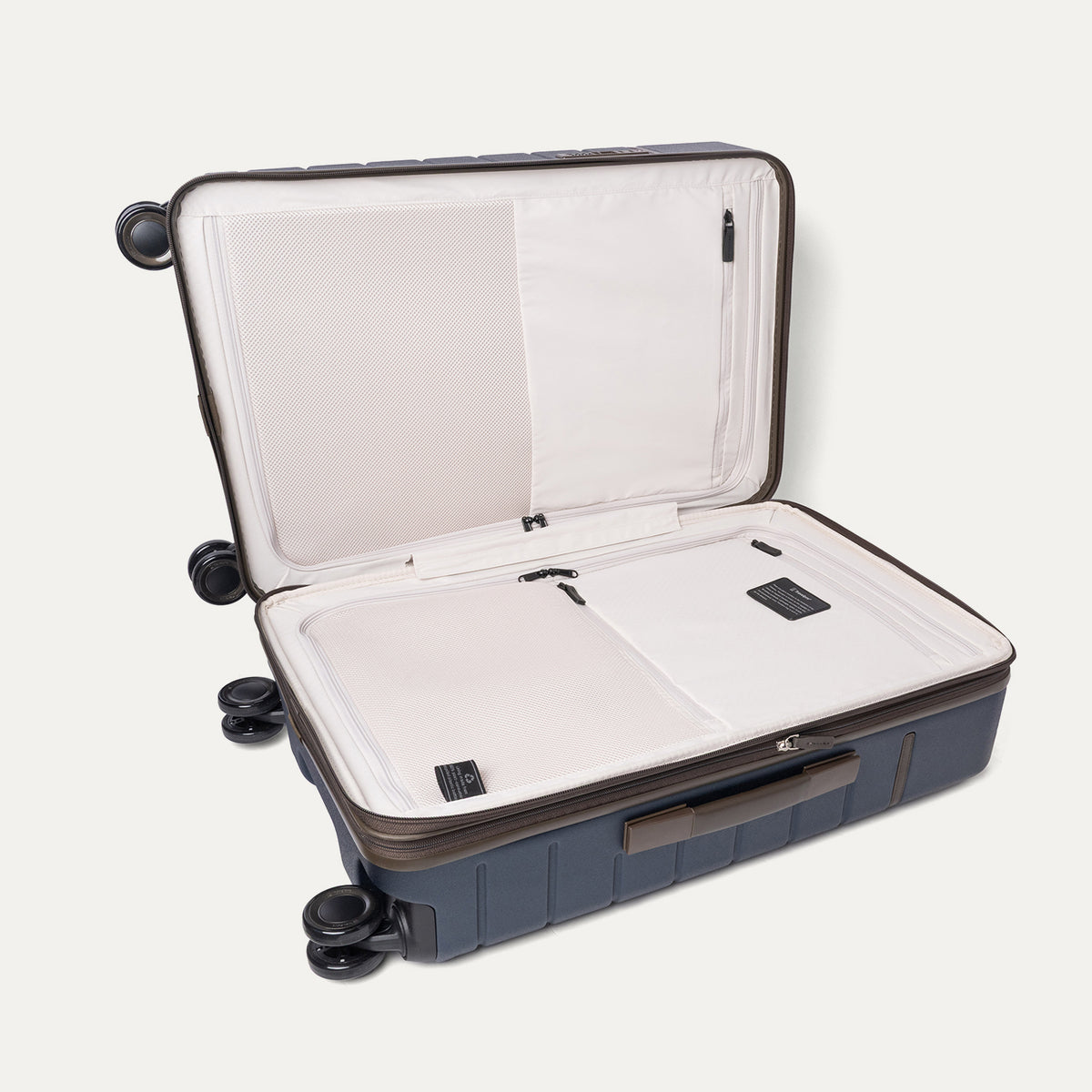 Open interior of the Travelpro Platinum Reserve Medium Check-In Hardside Spinner in Midnight Trail showing the zippered divider panel and dedicated pockets