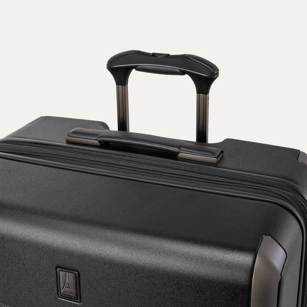 Close-up of the leather-wrapped top handle and PowerScope Lite extension handle on the Travelpro Platinum Reserve Large Check-In Hardside Spinner in Black Dust