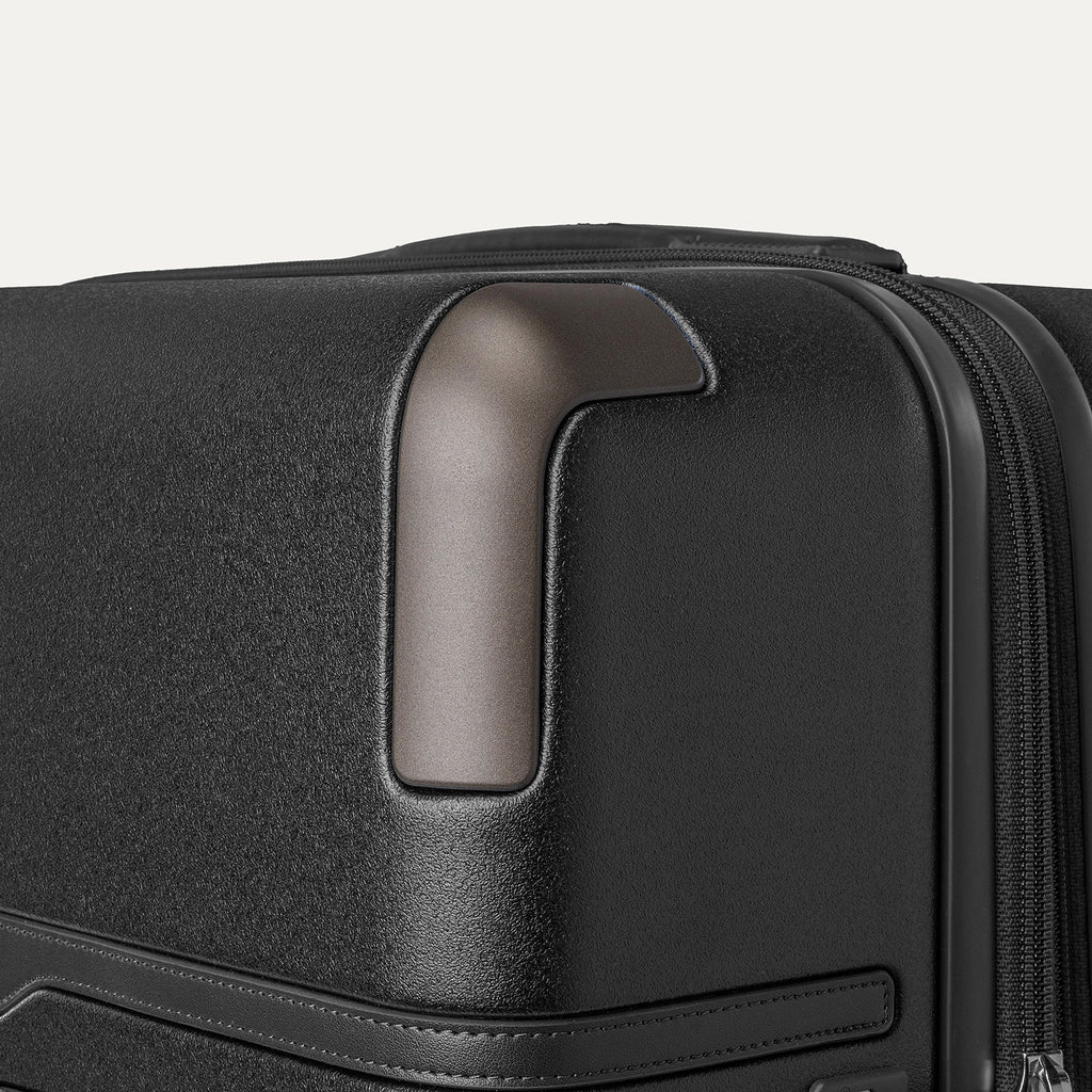 Close-up of the zinc corner armor on the Travelpro Platinum Reserve Large Check-In Hardside Spinner in Black Dust