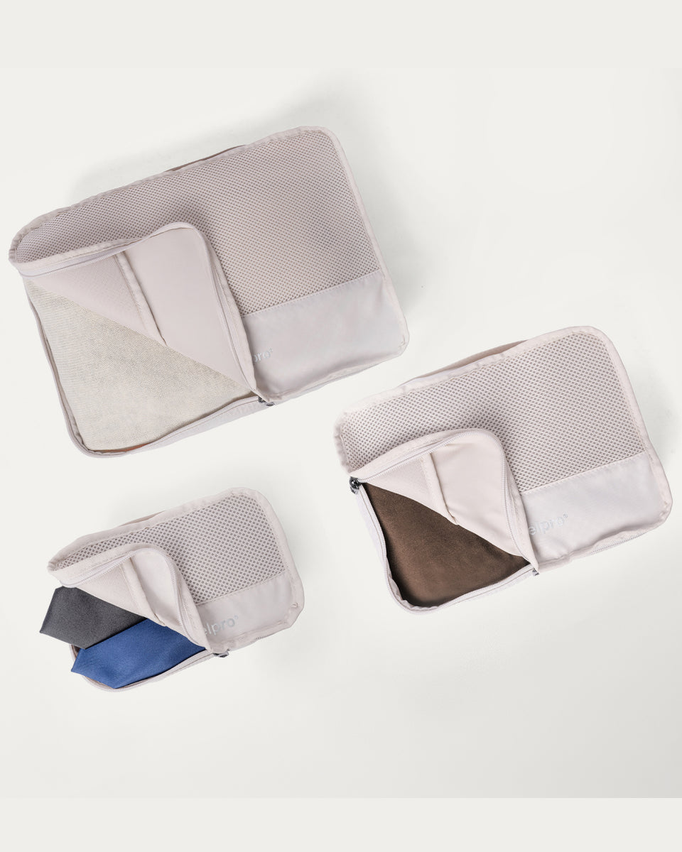 Packing cubes included with the Travelpro Platinum Reserve Large Check-In Hardside Spinner in Steel Blue, shown open with folded clothing