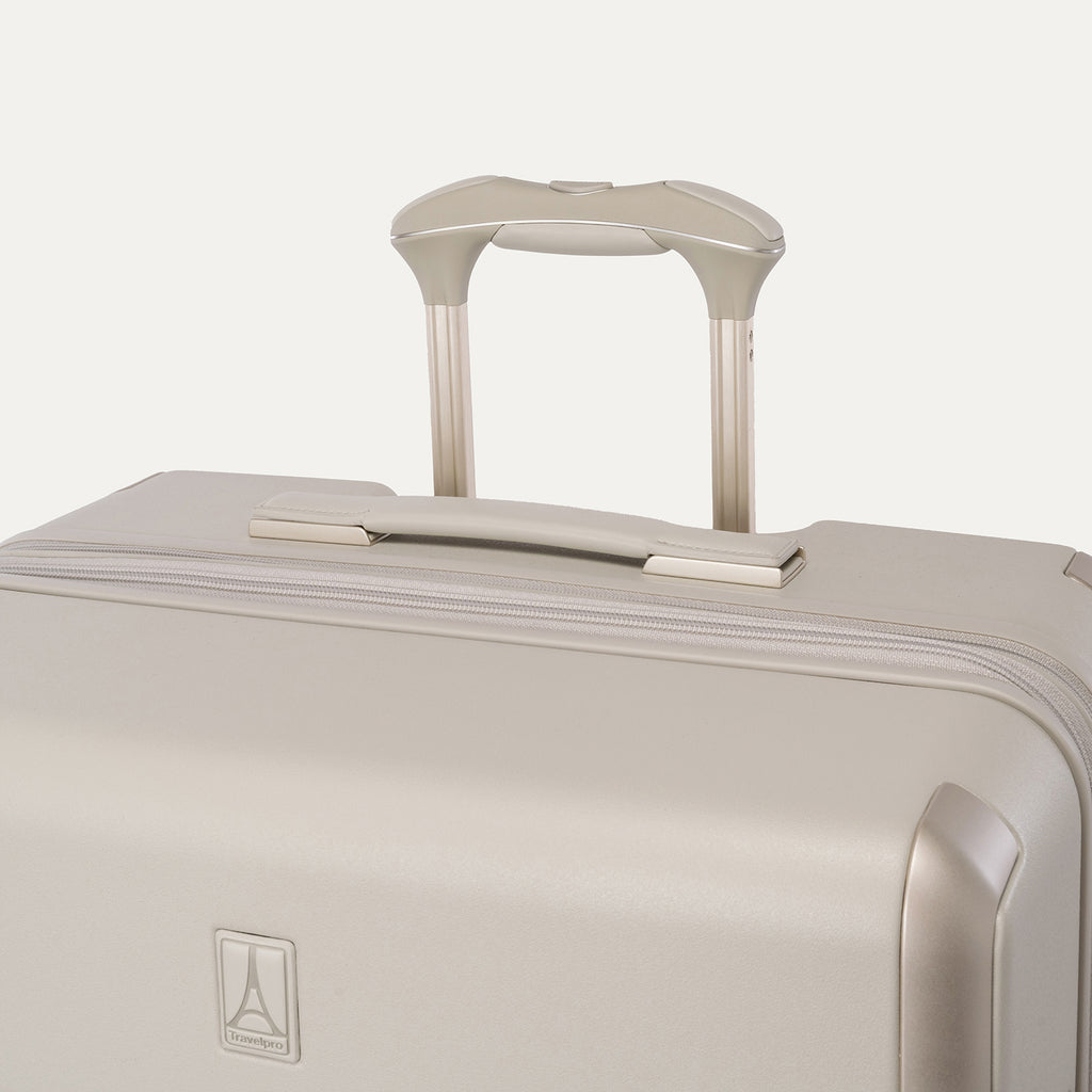 Close-up of the leather-wrapped top handle and PowerScope Lite extension handle on the Travelpro Platinum Reserve Large Check-In Hardside Spinner in Sandstone