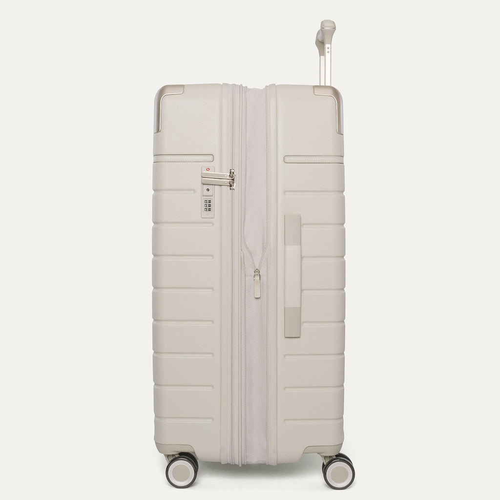 Side profile of the Travelpro Platinum Reserve Large Check-In Hardside Spinner in Sandstone, expanded for extra packing space