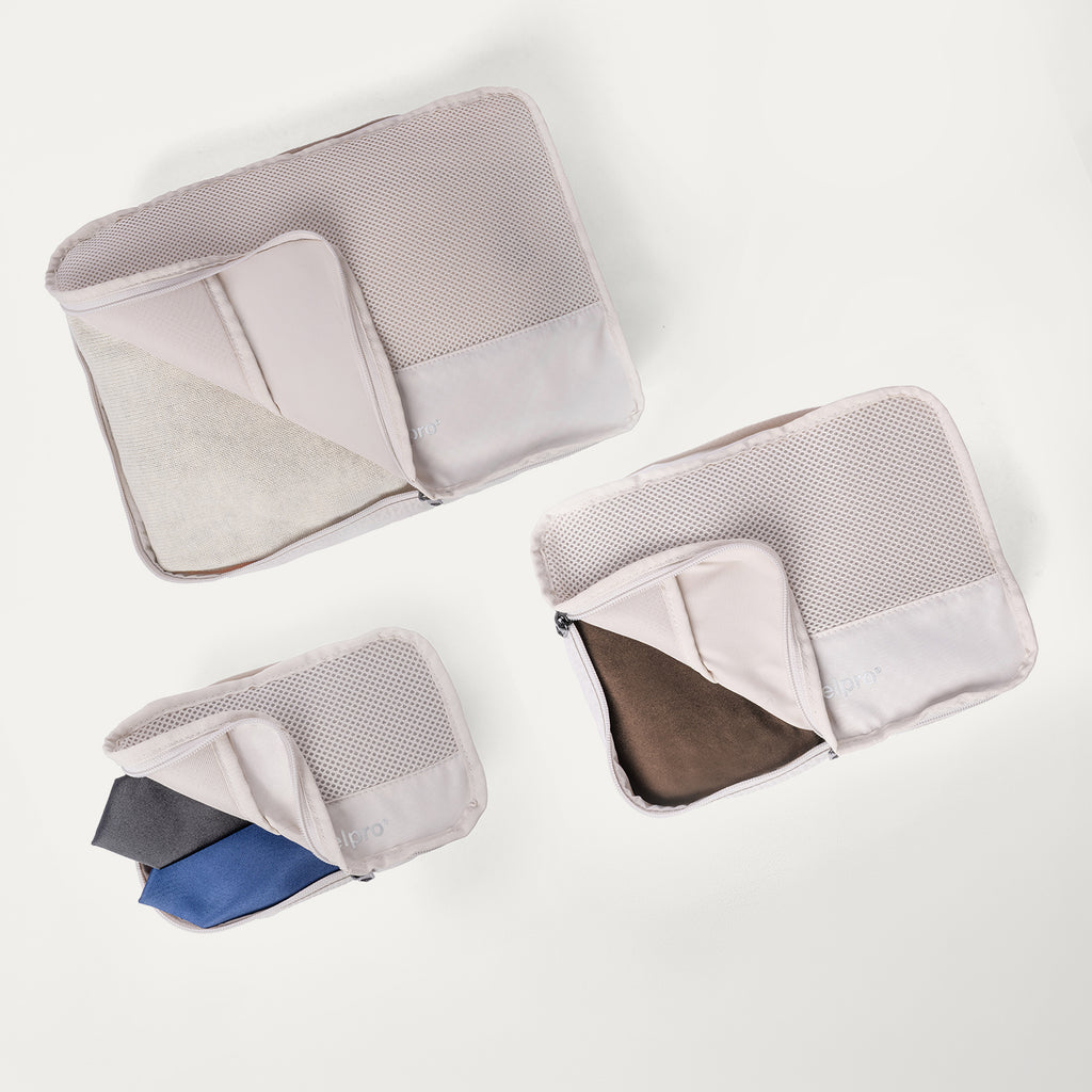 Packing cubes included with the Travelpro Platinum Reserve Large Check-In Hardside Spinner in Midnight Trail, shown open with folded clothing