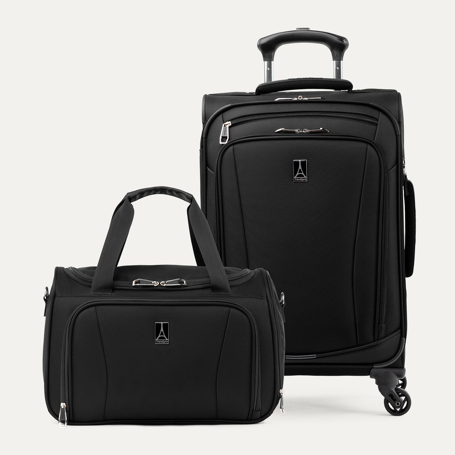 Three-quarter front view of the Travelpro Runway Tote / Carry-on Luggage Set in Black, showing a matching softside carry-on spinner and a compact tote bag with dual top handles, front zip pockets, and the Travelpro logo against a clean white background.