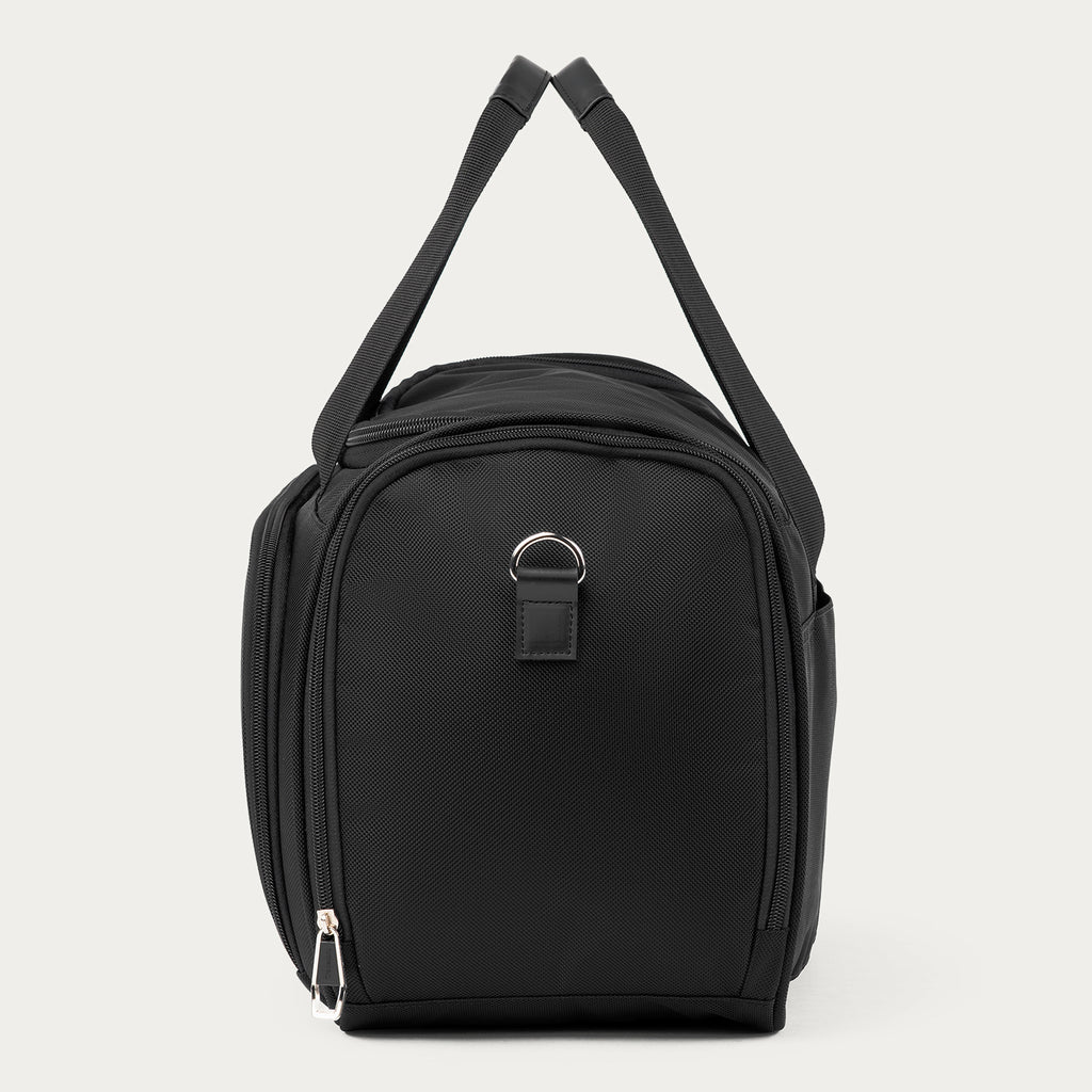 A black nylon Travelpro Runway Tote with a top zipper, side pockets, and a silver metal D-ring accent, shown against a light gray background.