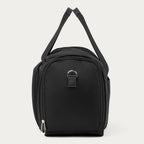 A black nylon Travelpro Runway Tote with a top zipper, side pockets, and a silver metal D-ring accent, shown against a light gray background.
