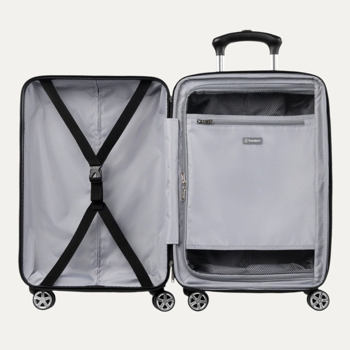 Open black hardside spinner suitcase showing interior with cross straps on one side and a zippered mesh divider pocket on the other.